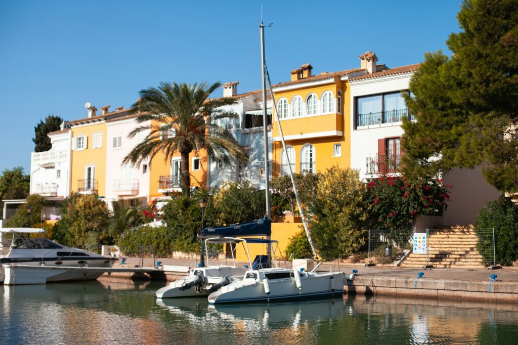 yellow colorful houses buildings and palm tree reflected in the water of canal